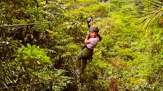 Mädchen gleitet lachend an einer Zipline durch den Dschungel bei einer Canopy-Tour – Costa Rica Familienreise