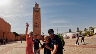 Familie hält einen Moment mit einem Selfie vor der Koutoubia-Moschee fest – Marokko Familienreise