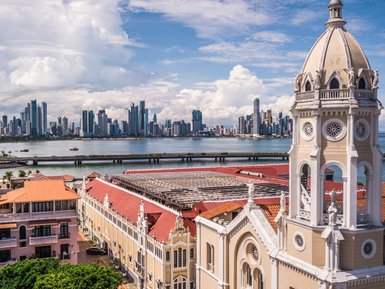 Der Blick auf das moderne Stadtbild von Panama City zeigt hohe Wolkenkratzer und das ruhige Wasser des Hafens im Vordergrund.