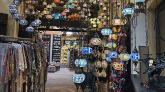 Bunte, hängende Lampen in einem geschäftigen Souk, die eine warme, einladende Atmosphäre schaffen.