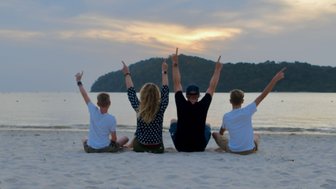 Familie genießt den warmen Sonnenuntergang am Strand von Langkawi – Malaysia & Borneo Reise mit Kindern