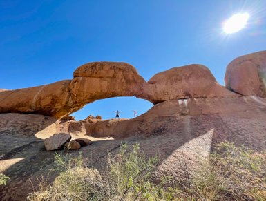 Zwei Personen stehen in einem Felsentor - Namibia Urlaub mit Kindern