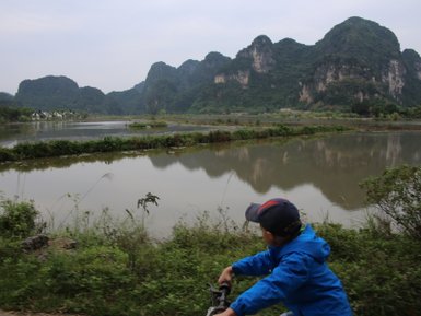 Junges Kind fährt Fahrrad entlang der Küste der Halong-Bucht – Vietnam Familienreise