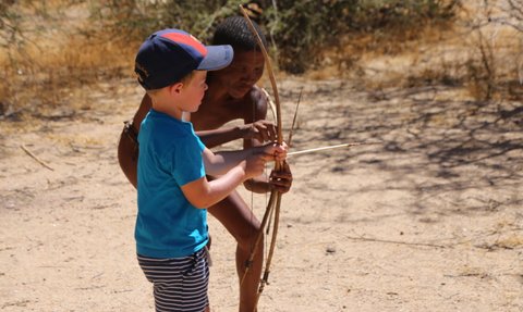 Ein Kind versucht einen Bogen zu spannen - Namibia Urlaub mit Kindern