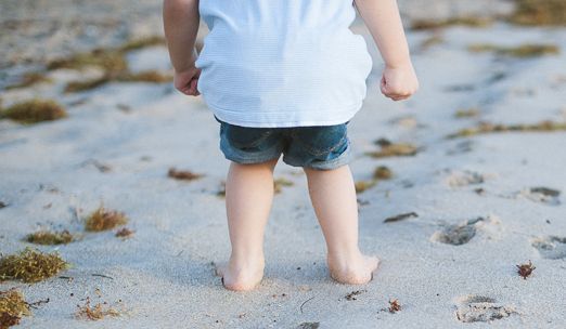 Fernreisen mit Kindern - Kind im Sand