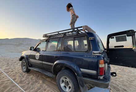 Junge auf einem Jeep in der Weißen Wüste mit Zelten im Hintergrund – Ägypten Reise mit Kindern