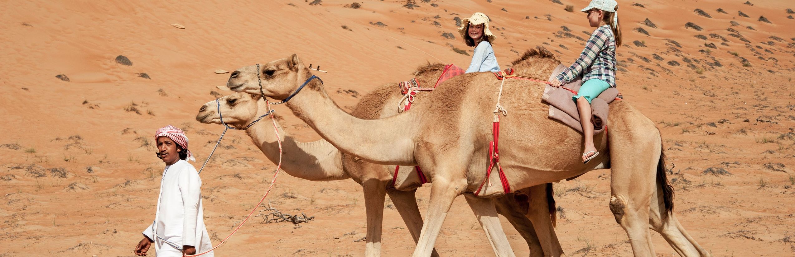 Oman for family - Oman mit Kindern - Kinder beim Kamelreiten in der Wüste