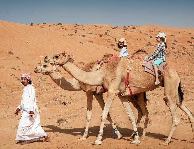Oman for family - Oman mit Kindern - Kinder beim Kamelreiten in der Wüste