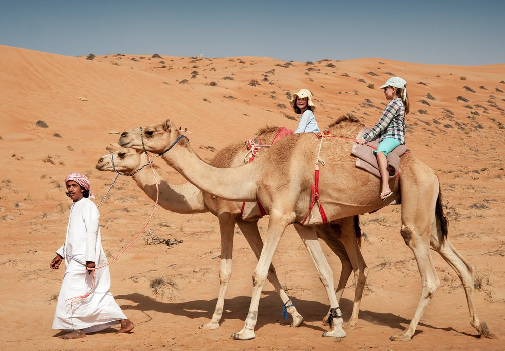 Oman Familienreise - Interview mit unserem Reiseleiter - Kinder auf Kamelen