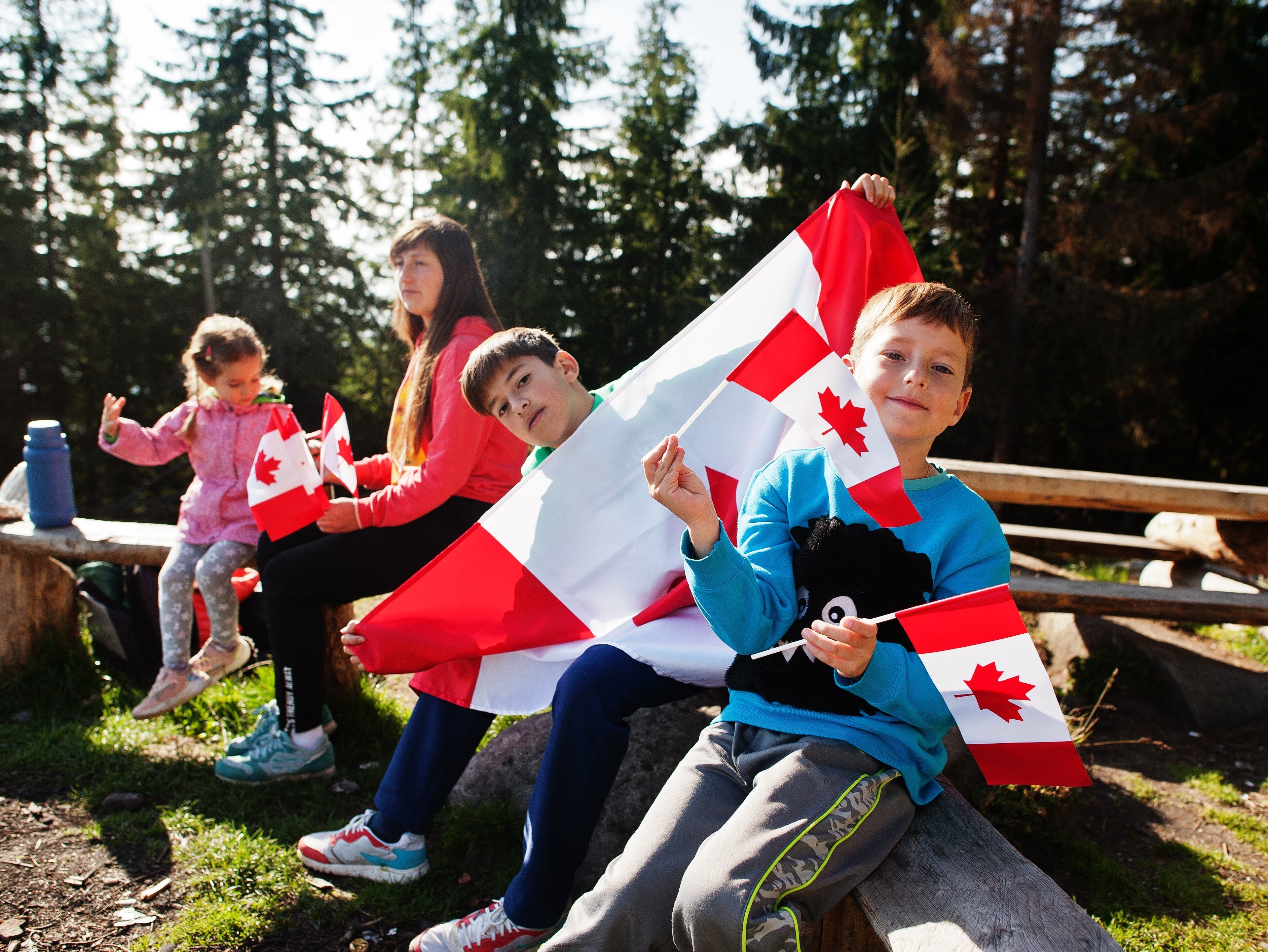 Neue Familienreisen 2026 - Ostkanada for family - Kinder mit kanadischer Flagge