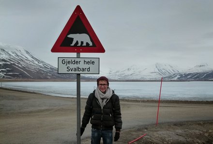 Familienreise Arktis - Arktis Reise mit Jugendlichen - Teenager am Schild mit Eisbär