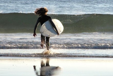 Algarve for family - Familienreise Algarve mit Kindern - Kind läuft mit Surfbrett ins Wasser