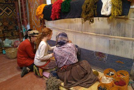 Marokko Familienreise - Kinder vor Berberteppichen Taznakht