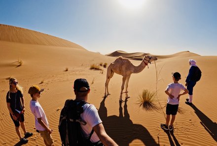 Marokko mit Kindern - Marokko mit Kindern Urlaub - Familie bei Kamel in der Wüste