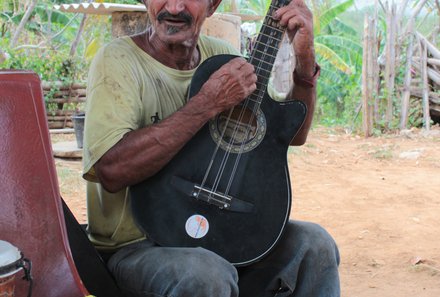 Familienreise Kuba - Kuba Casas for family - Mann spielt Gitarre im Zuckerrohrmühlental