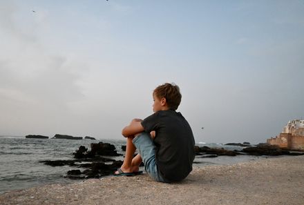 Familienurlaub Marokko - Marokko for family summer - Junge sitzt am Strand von Essaouira