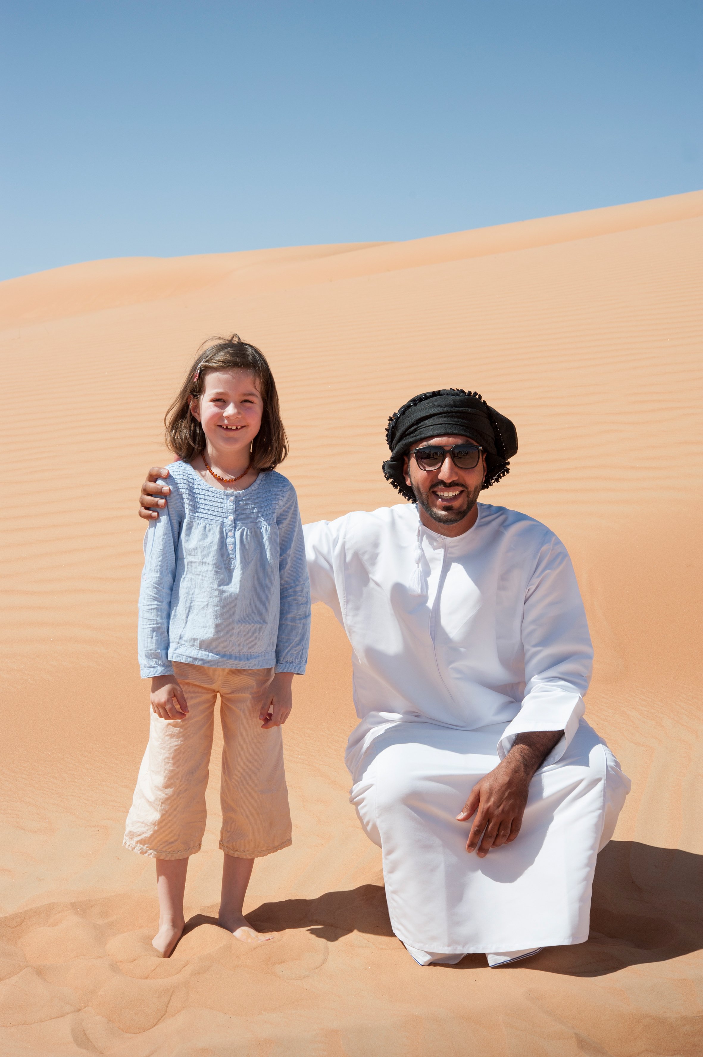 Oman mit Kindern - Oman Urlaub mit Kindern - Kind und Beduine in der Wüste