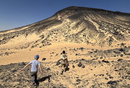 Kind und Guide bei der Erkundung der schwarzen Wüste - Ägypten Reise mit Kindern