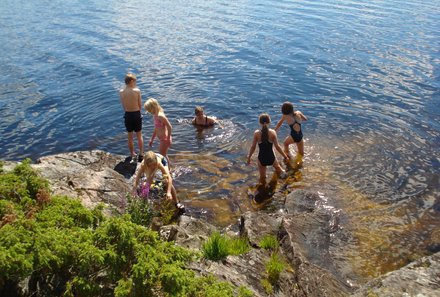 Familienreisen Schweden - Schweden for family im Kanu - Kinder plantschen im Wasser