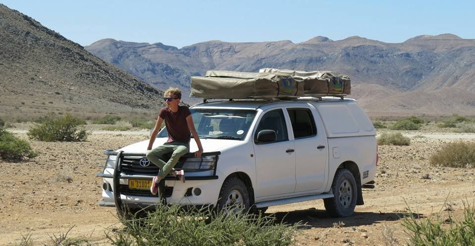 Camping in Namibia mit Kindern - Namibia Roadtrip mit Kindern - Jugendlicher bei Mietwagen mit Dachzelt