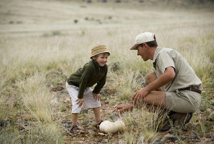 Familienreise Namibia - Namibia for family - Reiseleiter zeigt Kind Strausseneier