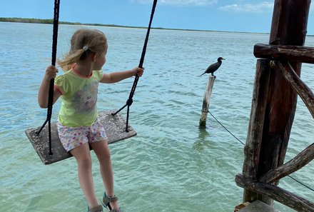 Fernreisen mit Kindern ab wann und wohin - Mexiko Urlaub mit Kindern - Kind auf Schaukel am Meer