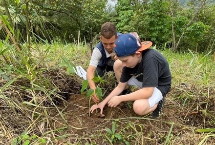 Familienurlaub Costa Rica - Costa Rica for family - Junge pflanzt Baum mit Guide