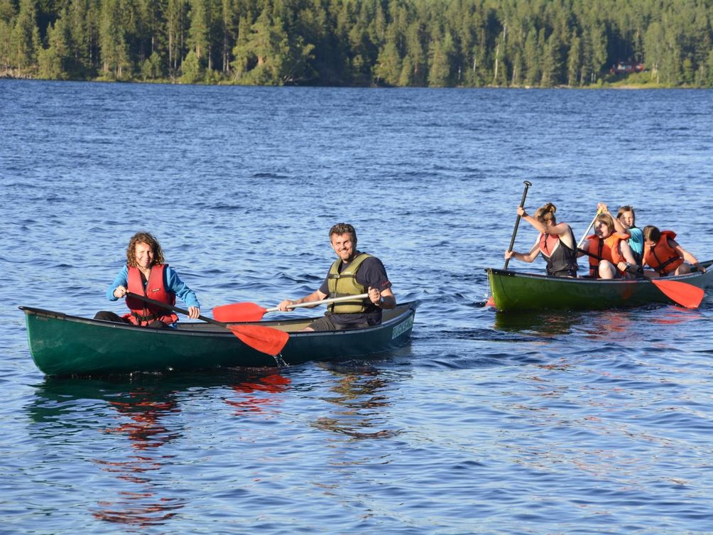 Kanutouren mit Kind - Familie paddelt auf See im Kanu