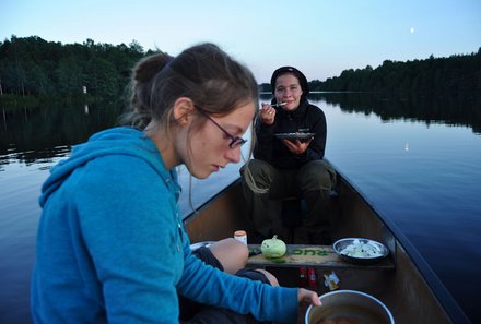 Schweden Familienreise - Schweden Kanu Family & Teens - Mädchen essen im Kanu