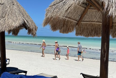 Mexiko mit Kindern - Mexiko Urlaub mit Kindern - Strohschirm und Liegen am Strand von Holbox