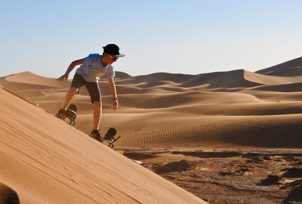 Familienreise Marokko - Marokko for family Deluxe - Kinder beim Sandboarding in der Wüste