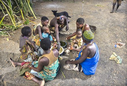 Tansania Familienreise - Tansania Family & Teens individuell - Hadzabe - Gruppe beim Essen auf dem Boden