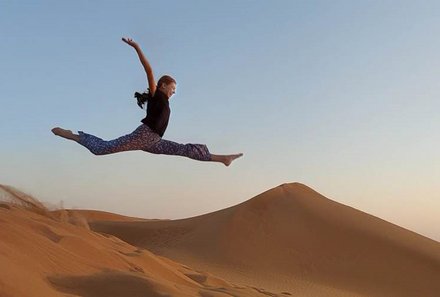 Oman Familienreise - Oman for family - Mädchen springt in Dünen