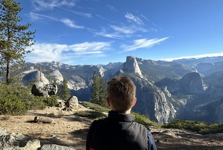 USA Familienreise - USA Westküste for family - Yosemite Nationalpark - Junge blickt auf Half Dome
