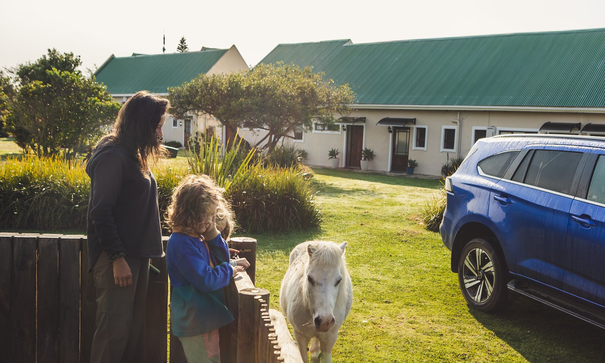 Südafrika Blog Artikel - Mutter und Kind beobachten ein weißes Pony – Südafrika mit Kindern