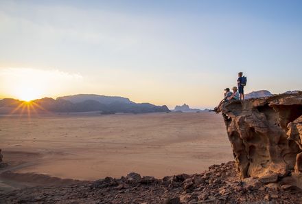 Jordanien Rundreise mit Kindern - Wadi Rum - Kinder beobachten auf Felsen den Sonnenaufgang