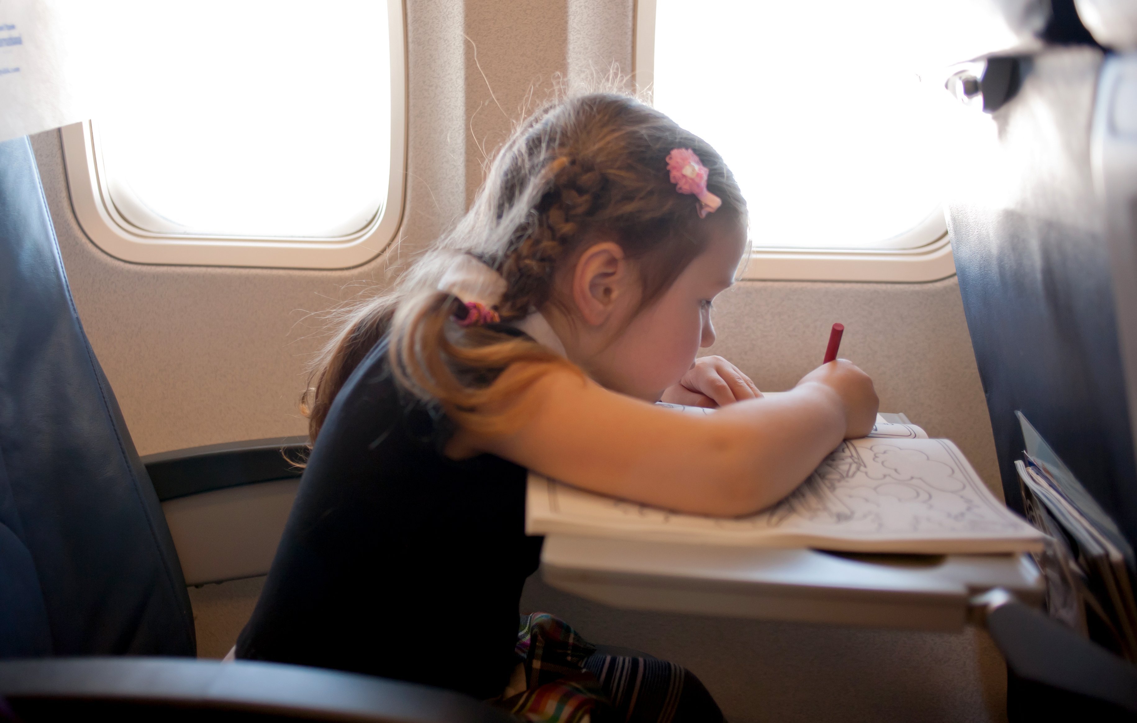 Reisespiele für Kinder - Beschäftigung für Kinder im Flugzeug Auto - Mädchen spielt im Flugzeug
