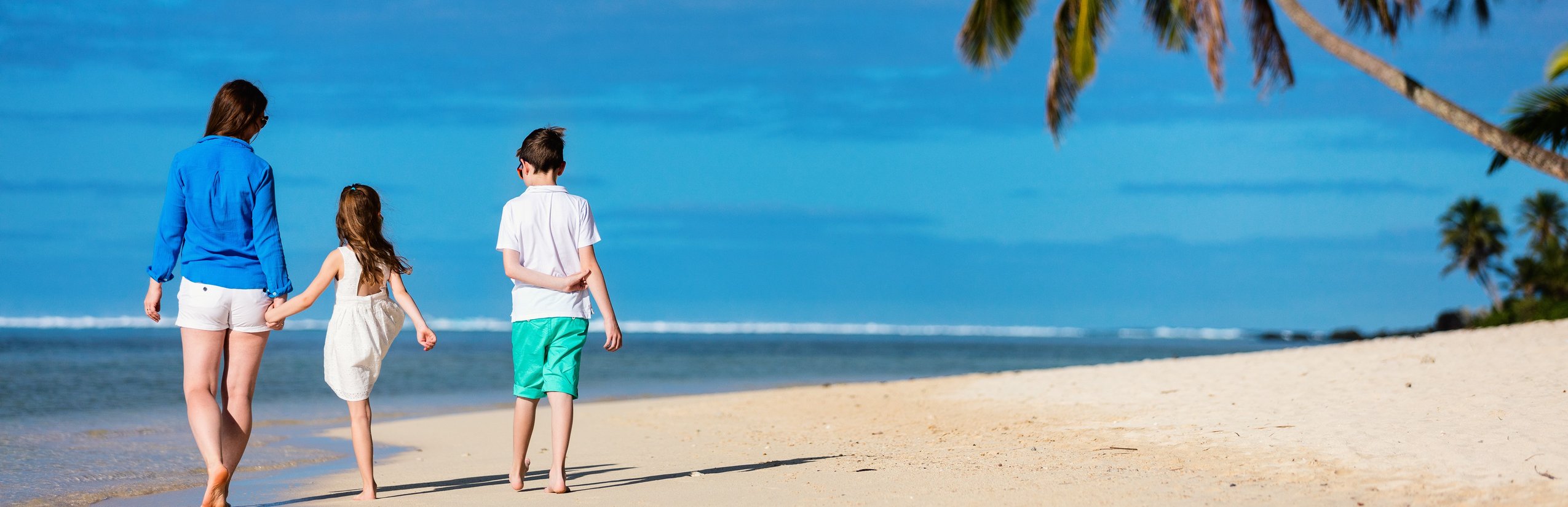 neue Fernreiseziele mit Kindern 2025 - Familie am Strand