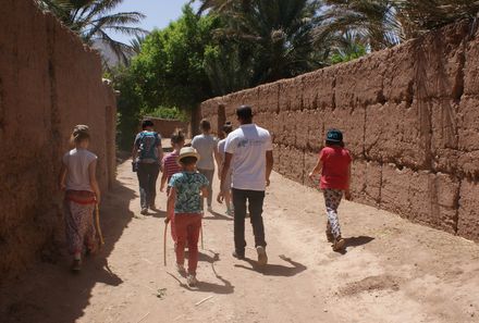 Marokko mit Kindern - Familien laufen durch Dattelplantage