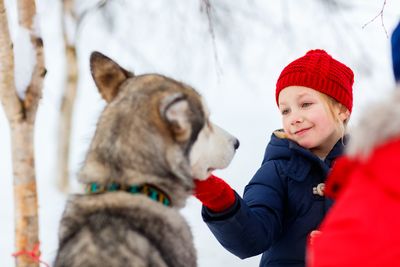 Finnland Familienurlaub - Finnland Winter for family - Mädchen streichelt Husky