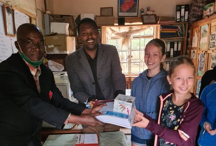 Tansania Familienreise - Tansania for family - Schulbesuch - Kinder überreichen Spenden