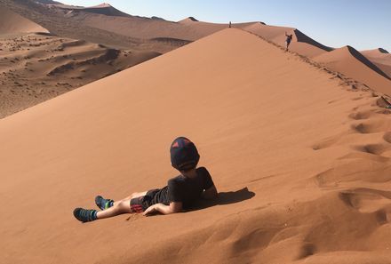 Namibia mit Kindern - Namibia individuell - Kind liegt im Sand der Dünen