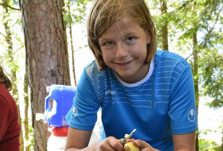 Familienreisen Schweden - Schweden for family im Kanu - Junge schält Kartoffel