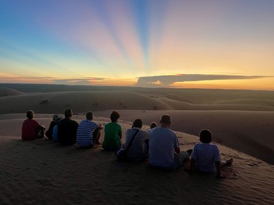 Familienreise Oman - Oman mit Kindern - Gruppe im Oman beobachtet Sonnenuntergang Familienreise Oman - Oman mit Kindern - Gruppe im Oman beobachtet Sonnenuntergang