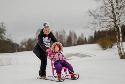Familienreise Estland - Estland for family Winter - Frau mit Kind auf dem Tretschlitten