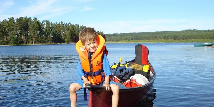 Fernreisen mit Kindern - Planungshilfe für entspannte Familienreisen - Kind mit Rettungsweste im Boot 