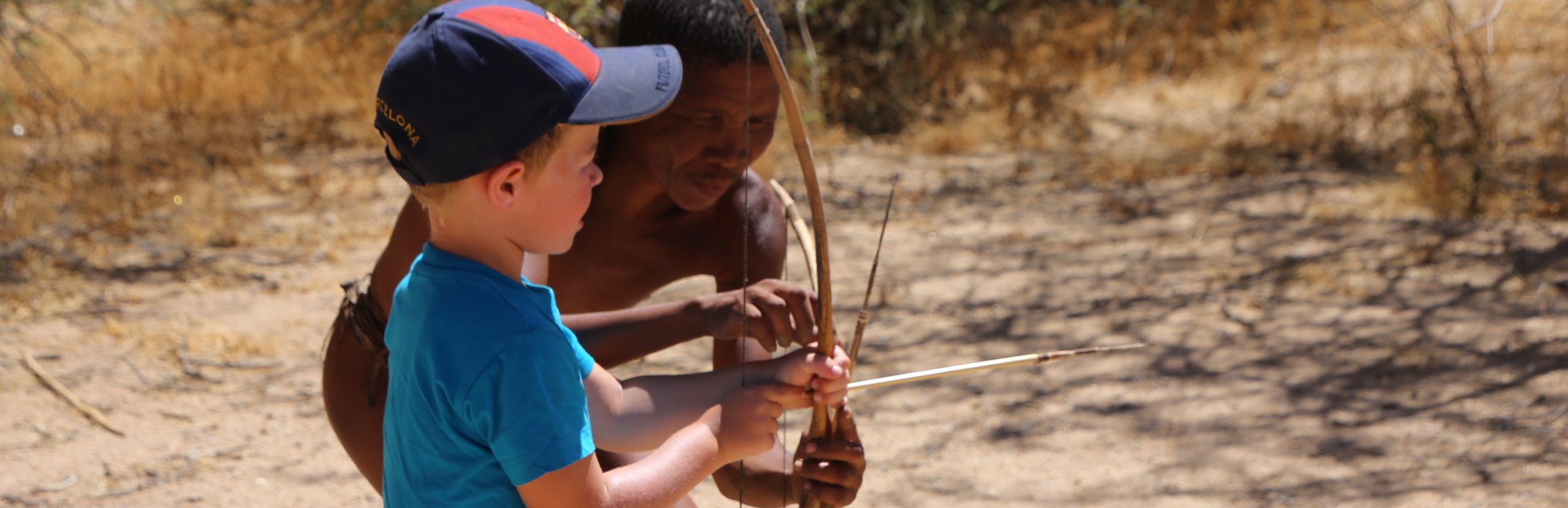 Namibia mit Kindern - Namibia for family individuell - Kind neben einem San Buschmann