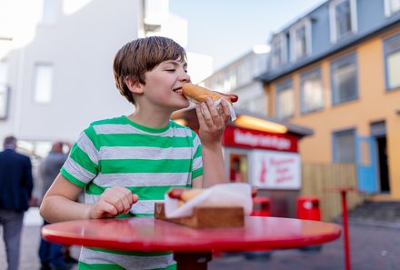Island Familienreise - Island for family - Kind isst Würstchen im Brot