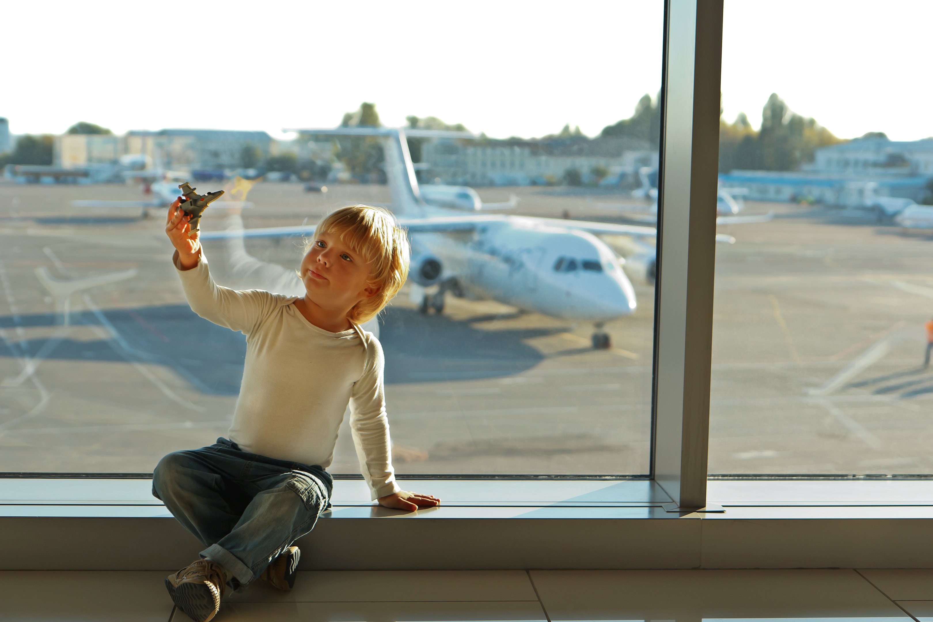 Reisespiele für Kinder - Beschäftigung für Kinder im Flugzeug Auto - Kind spielt mit Spielflugzeug