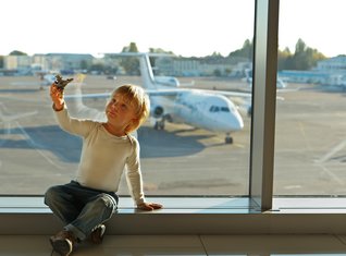 Kind sitzt am Flughafen